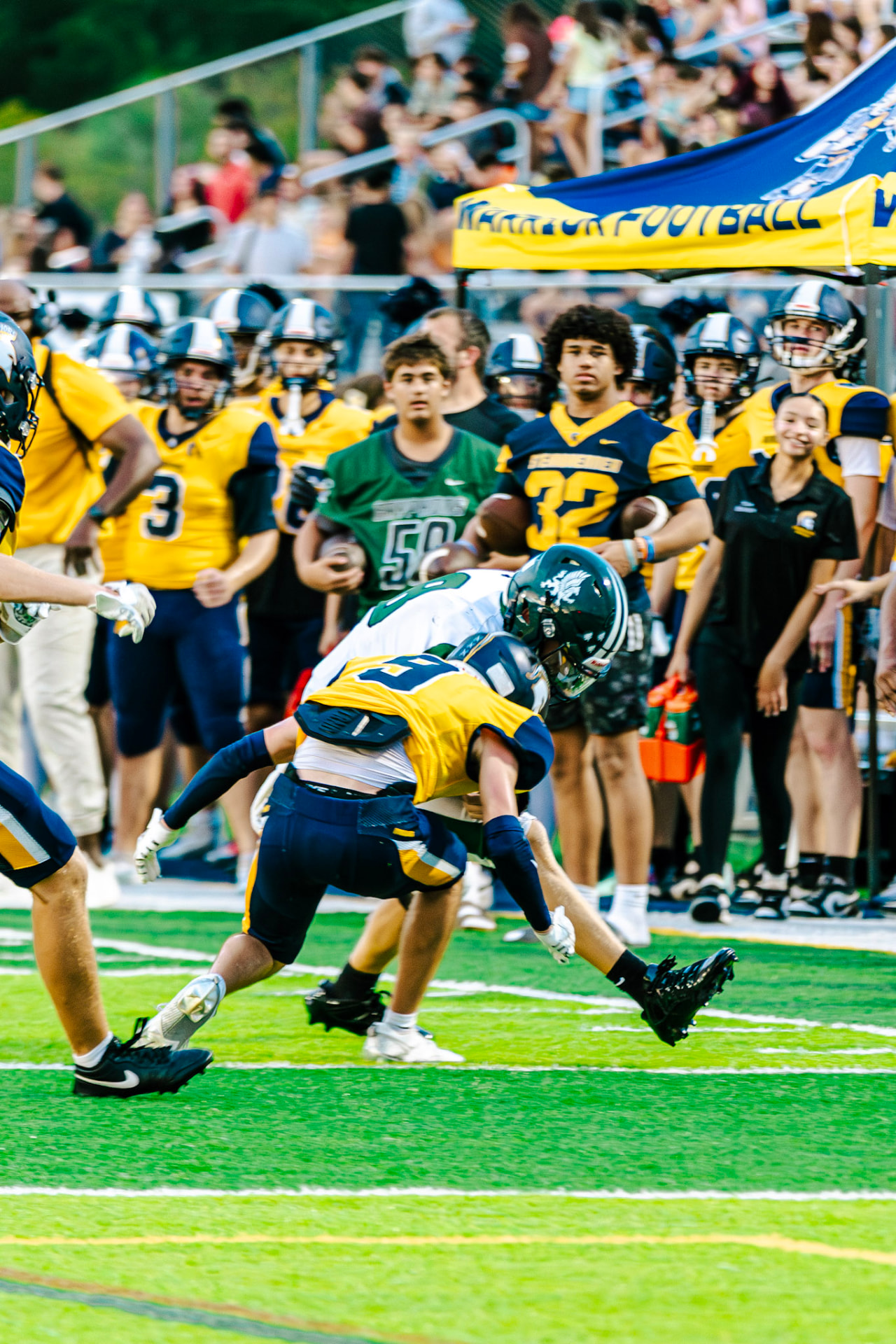 Tackle made at the sideline with teammates watching